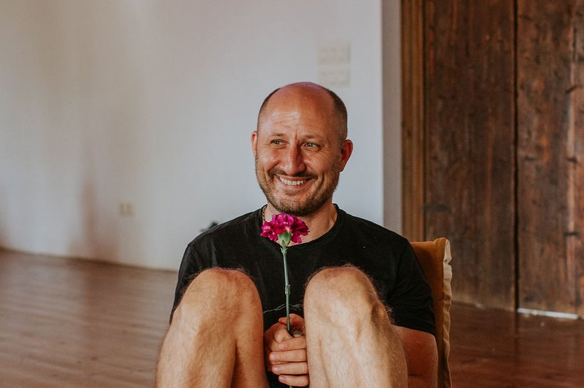 Martin, an Alalaho retreat participant, smiling with a flower
